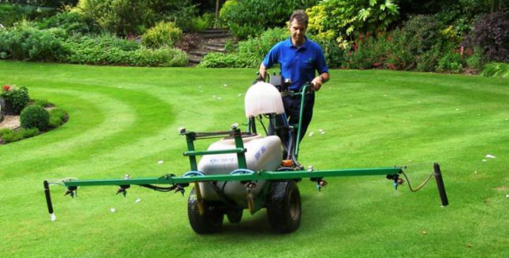 Man using machinery to treat lawn