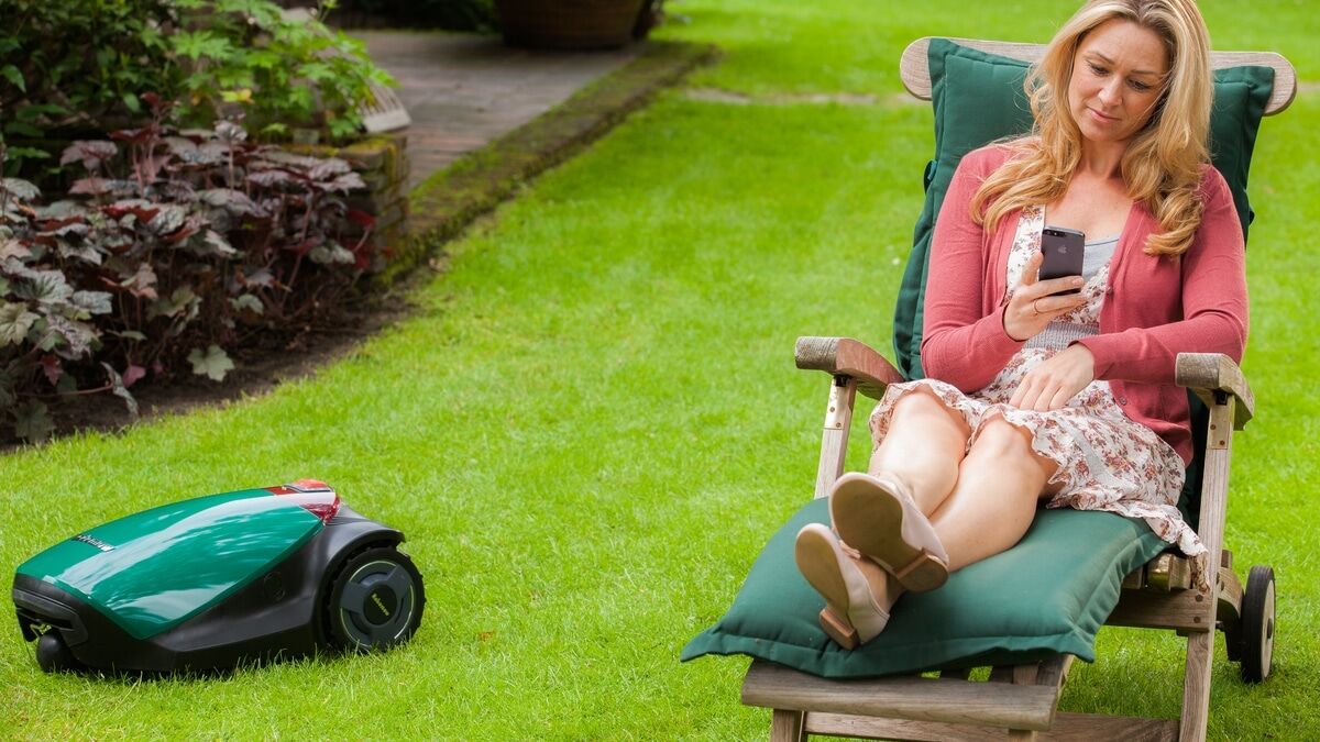 Woman on deck chair next to robot mower